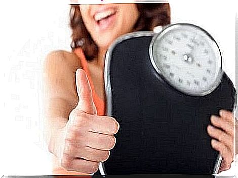 Woman showing a weight scale with positive numbers