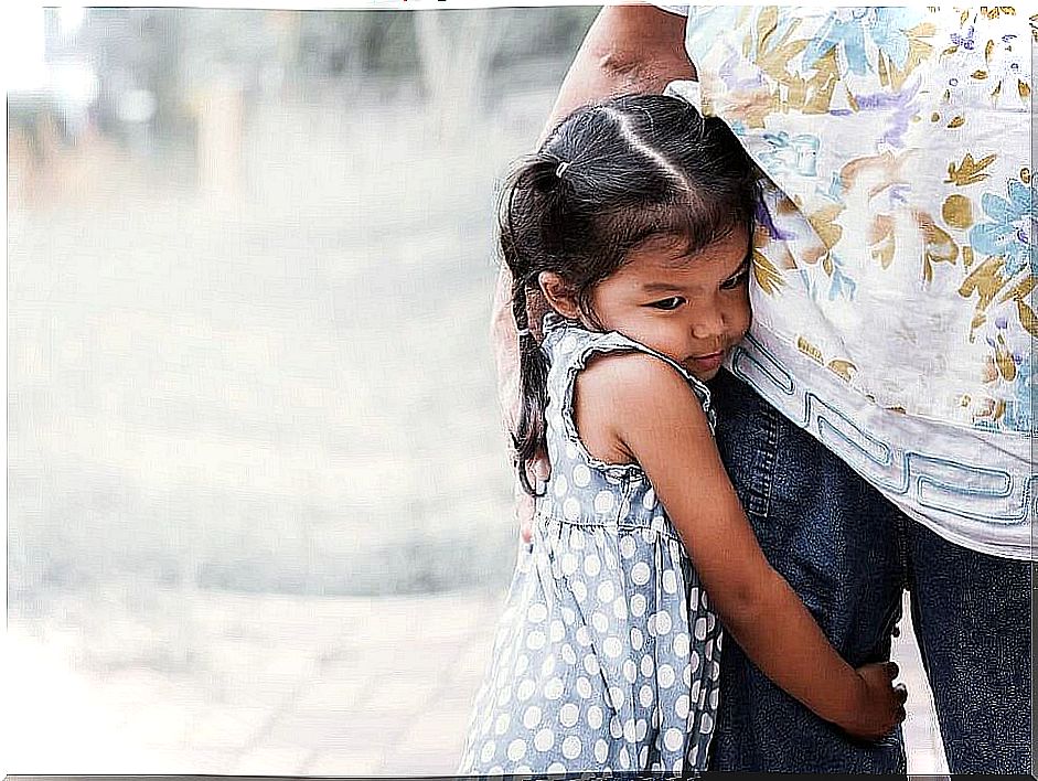 Girl clinging to her mother before going to school lengthening the farewell, one of the mistakes parents make when their children go to school.