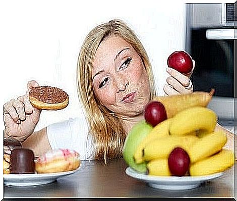 Woman choosing between healthy food or junk food