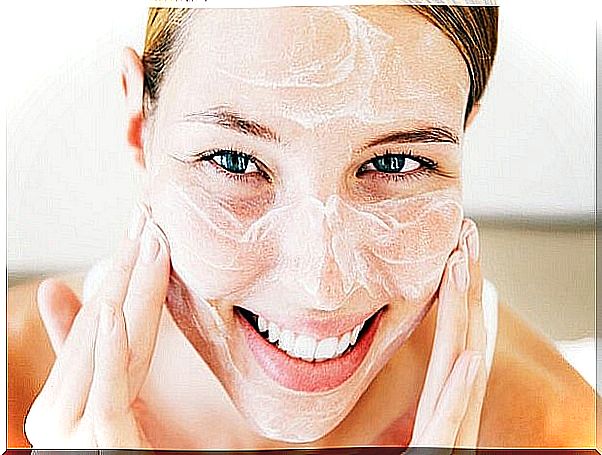 Smiling Young Woman Applying Face Cream