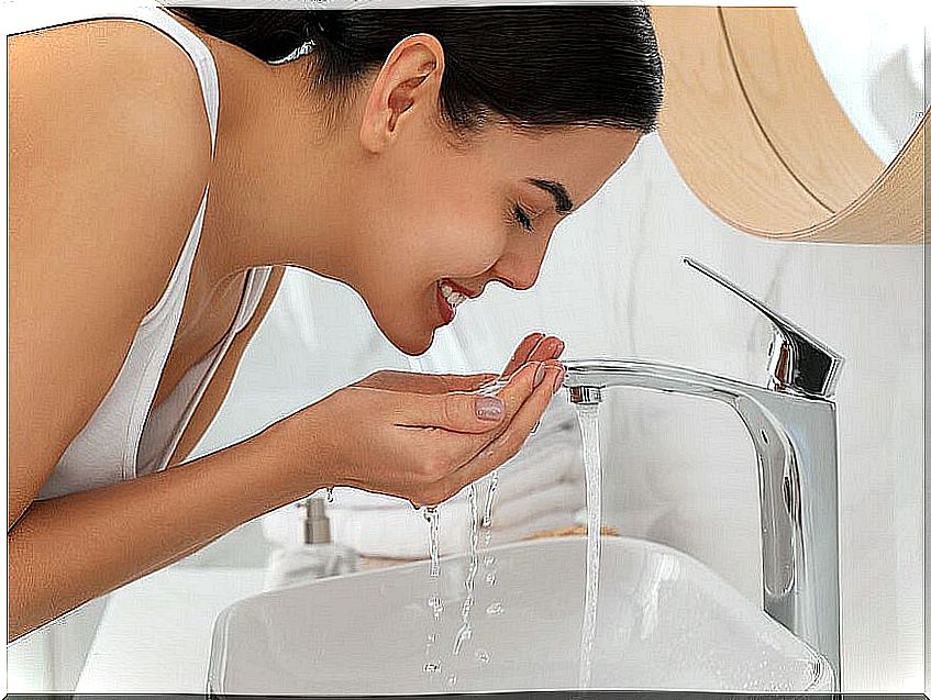 Woman washing her face in the sink