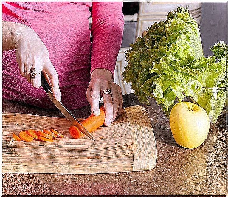 Pregnant girl chopping carrot