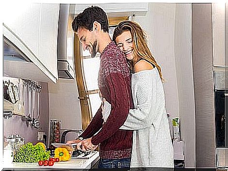 Girl hugging her partner in the kitchen.