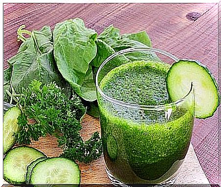 Green smoothie and vegetables: cucumber, spinach and parsley.