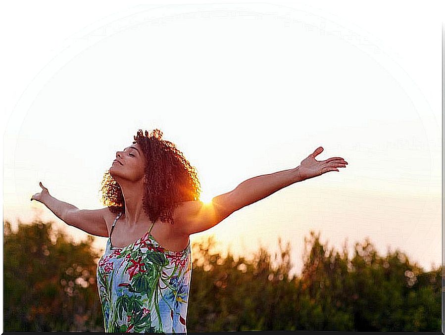 Young woman with open arms takes air giving herself a break and breaking with routine.